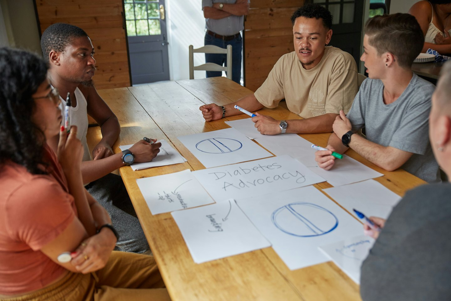 Un team che fa brainstorming di idee attorno a un tavolo di legno rustico.